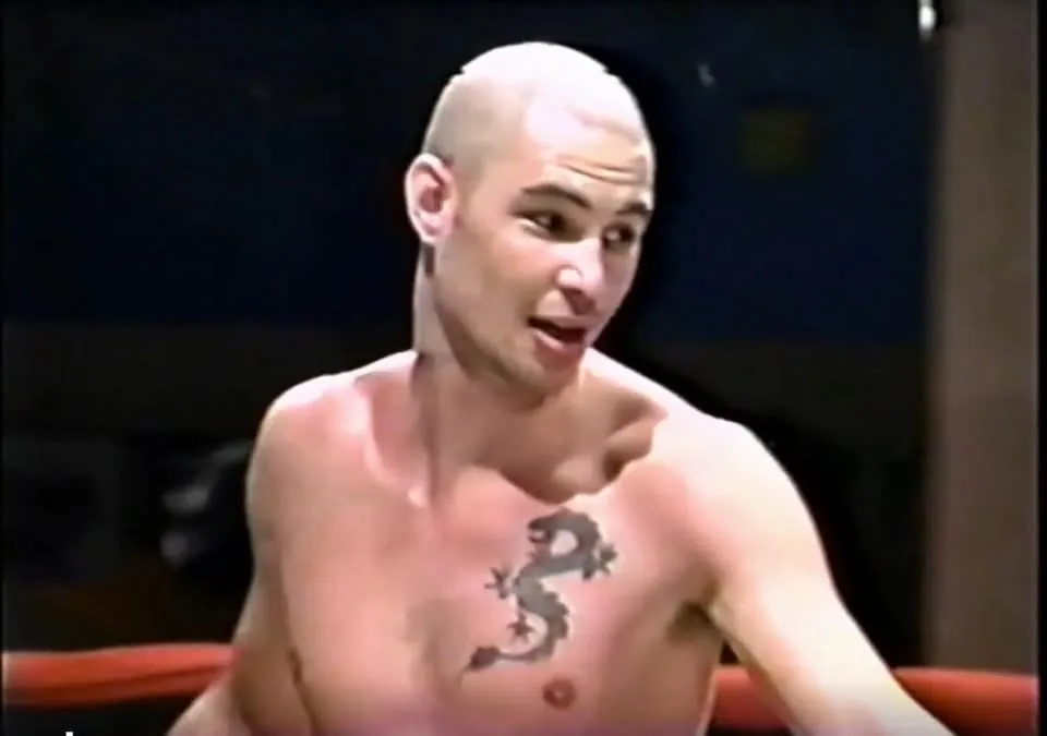 Daniel in the ring during his competitive kickboxing days, red ropes visible behind him.
